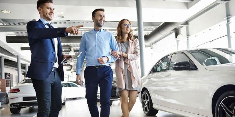 Car shopping couple walking around dealership